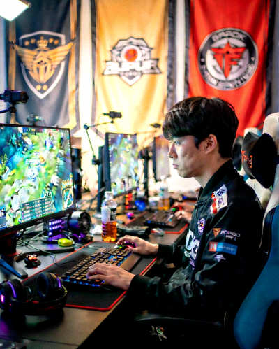 明星电竞选手Faker在训练基地专注地看着电脑屏幕，神情严肃